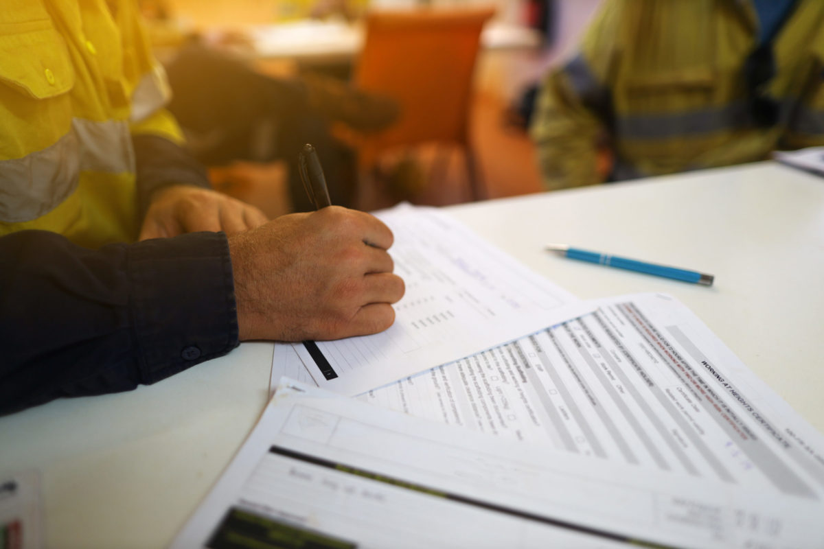 Working at heights permit book placing on the table, defocused c